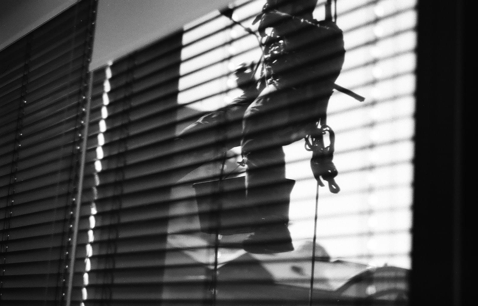 Мойщик окон спускается вниз на верёвке