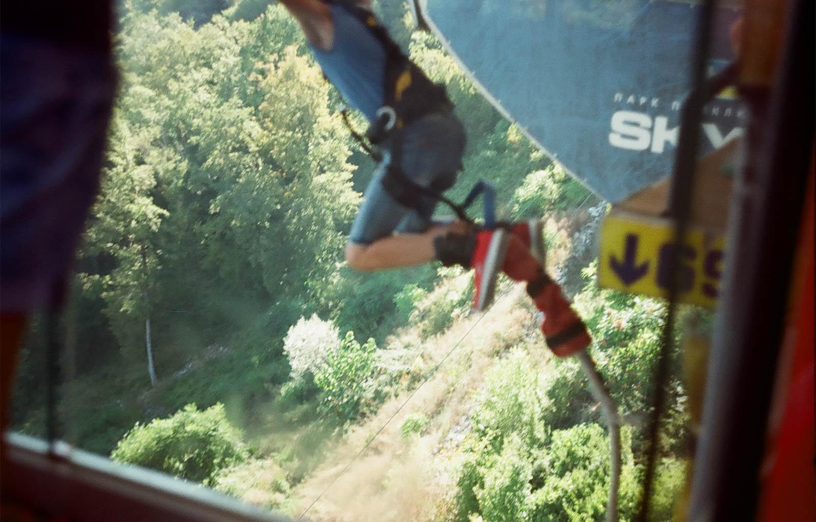 Человек, привязанный резиновым канатом, прыгает вниз