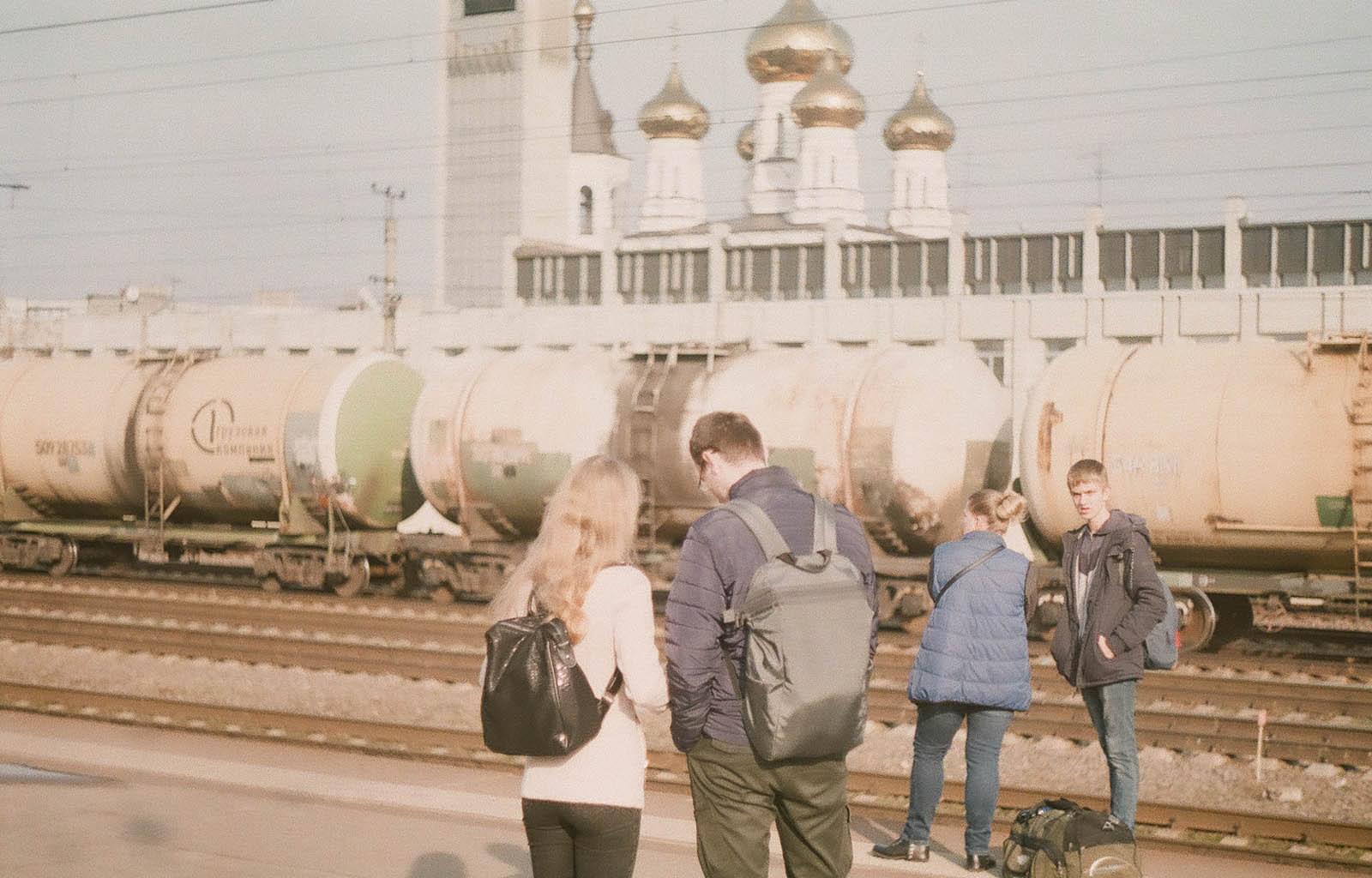 Люди на фоне железнодорожных цистерн