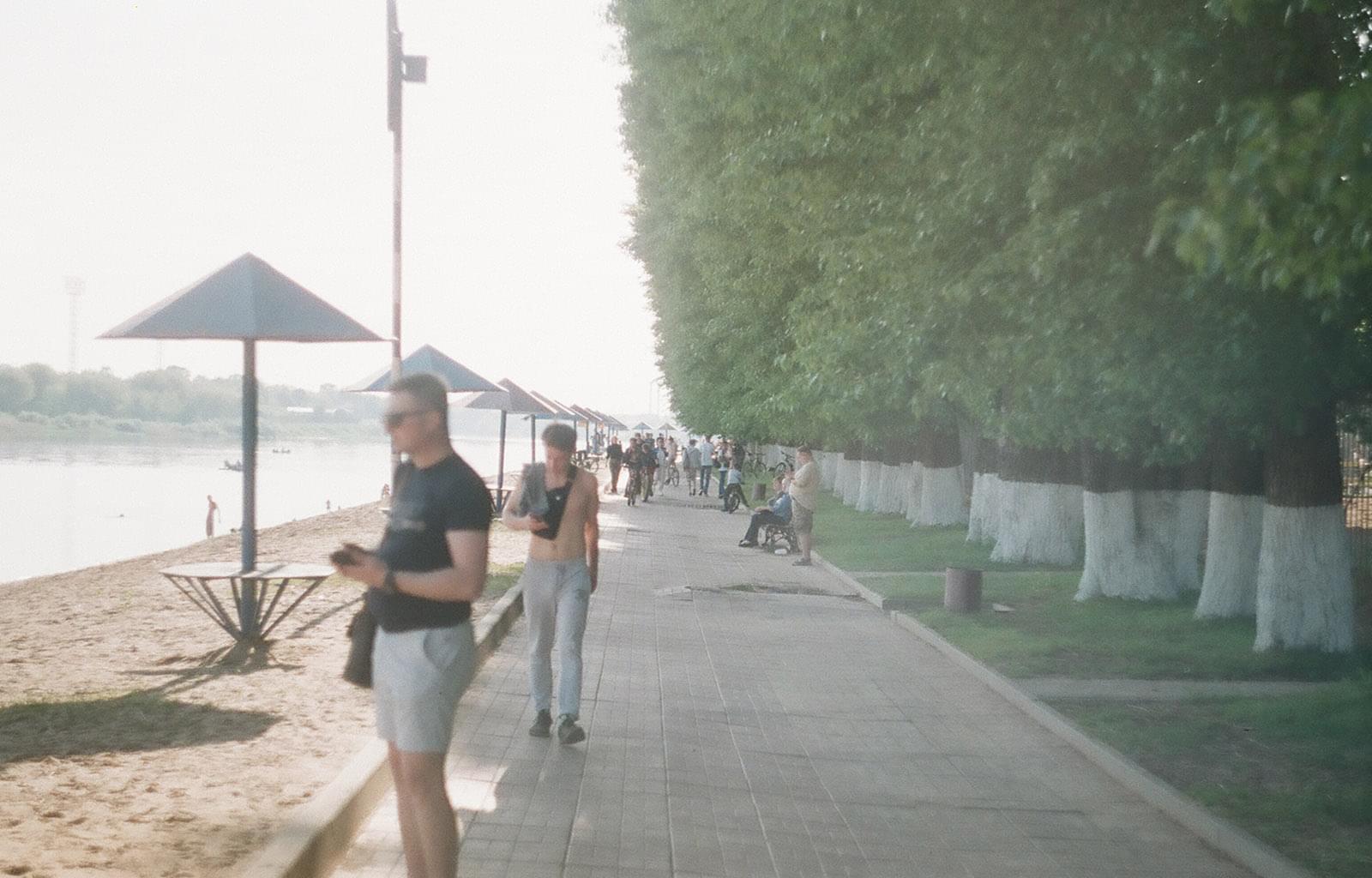 Люди идут по набережной городского пляжа