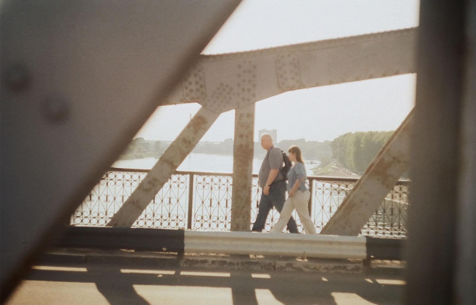 Люди идут по мосту на противоположной стороне